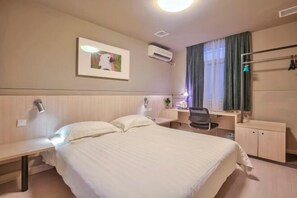 A hotel room with a bed, desk, chair, and wardrobe. - Jinjiang Hotel (Taizhou Huangyan Jiufeng Park) (Taizhou)