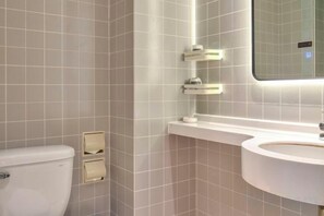 A bathroom with a toilet, sink, and mirror.