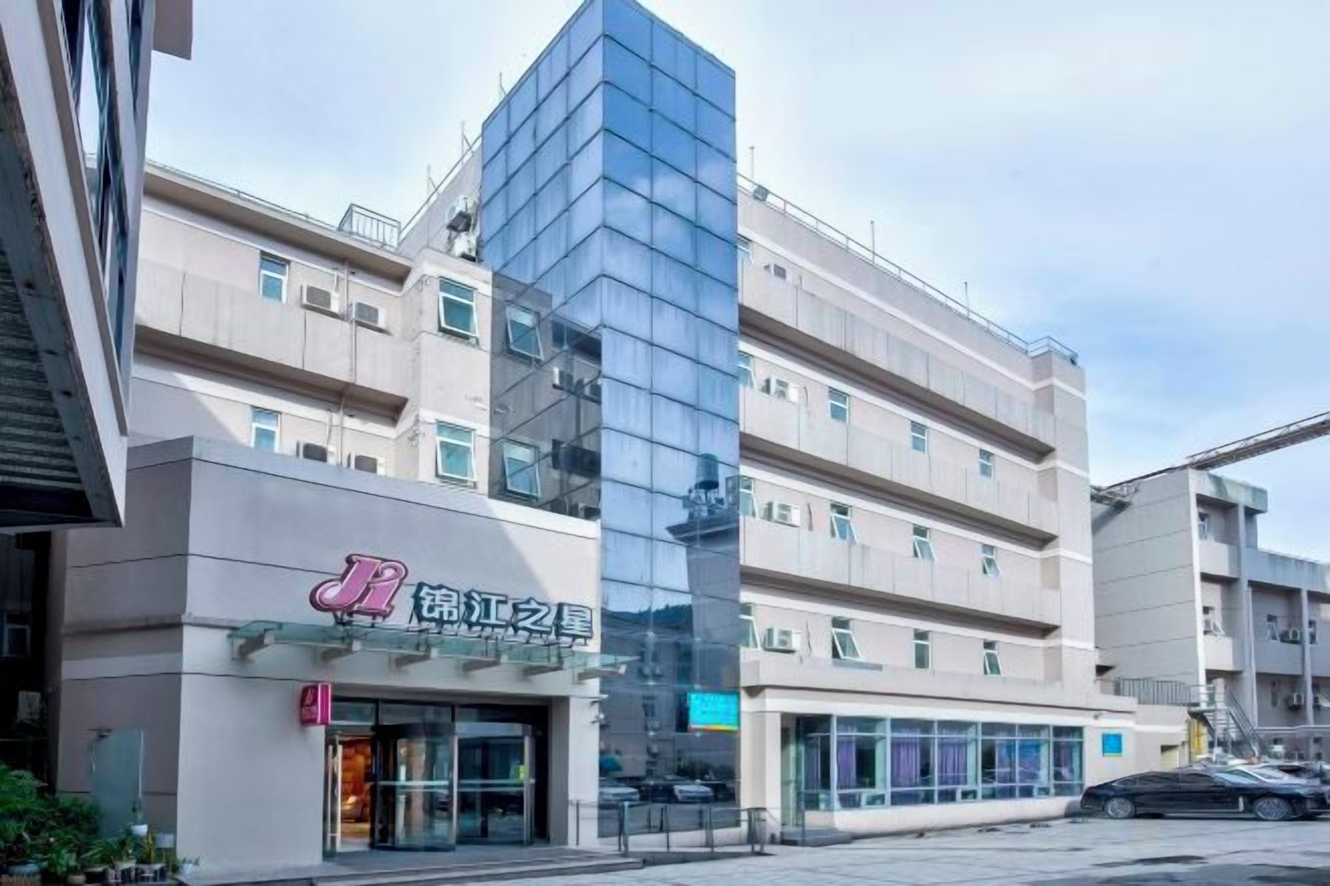 Un edificio de varios pisos con fachada de vidrio moderna y señalización que indica un uso comercial o empresarial.