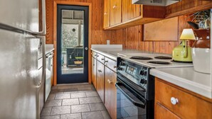 Una cocina compacta con armarios de madera, estufa y refrigerador.
