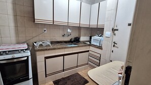 A compact kitchen with a stove, microwave, and sink.