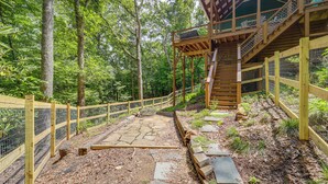Una terraza de madera con un sendero de piedra que lleva a una zona cubierta con escaleras.