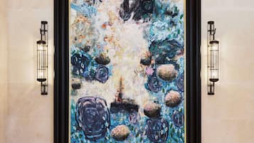 A framed abstract painting with a textured surface and a mix of blue and white tones.