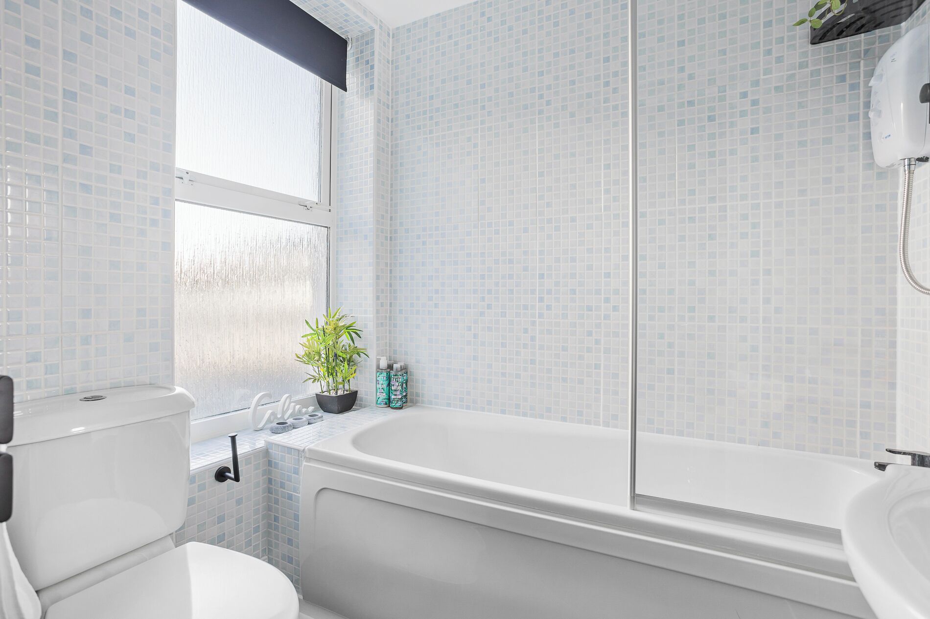 Ein Badezimmer mit Badewanne, Toilette und einem Fenster mit Aussicht.
