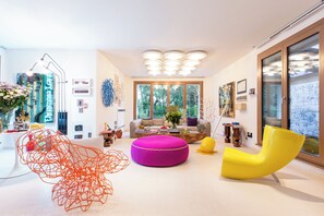 Relax in this stylish living room with a large window, comfortable sofa, and vibrant artwork.