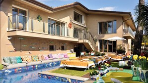A two-story house with a swimming pool, outdoor furniture, and a balcony with a view of the pool. -  Magic Forte (Forte dei Marmi)