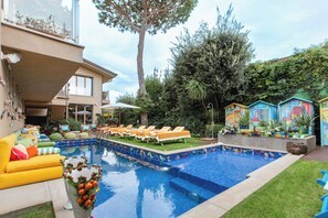 Relax by the pool surrounded by lush greenery and comfortable seating options.