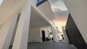 A modern building with a flat roof, large windows, and a gated entrance. - Luxury Villa Tavares Bautistas (Puerto Plata)
