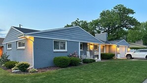 A single-story house with a front porch, a garage, and a well-maintained lawn.
