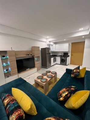 Una sala de estar moderna con un sofá, una mesa de centro y una televisión.