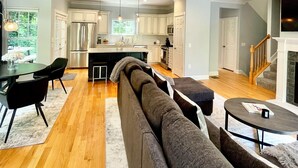 A modern kitchen with white cabinets, a central island, and stainless steel appliances. - Modern House in Clifton Gaslight - 3 BR 3BA with Walkable Shops and Restaurants (Cincinnati)