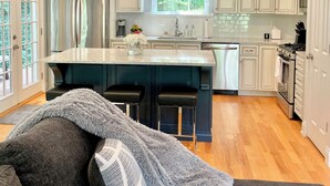 A modern kitchen with white cabinets, stainless steel appliances, and pendant lighting. - Modern House in Clifton Gaslight - 3 BR 3BA with Walkable Shops and Restaurants (Cincinnati)