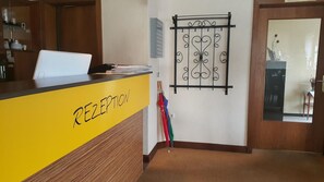 Mostrador de recepción con frente amarillo y una placa que dice "RECEPTION".