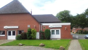 Un edificio de ladrillo con un letrero que indica que es un 'Landhaus Wachsendorf' y un 'Clubrestaurant'.
