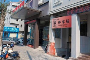 Un bâtiment avec une enseigne indiquant un parking et une autre indiquant un service.