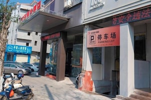 A building with a sign for a parking lot and another sign for a service.