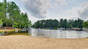 A lakeside area with boats, a sandy beach, and dense trees. - 9 Mi to Cranmore Mtn Resort: 'Lofty Dreams' Cabin (Center Conway)