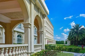 A building with classical architecture, featuring arched windows and columns, surrounded by well-maintained greenery and a clear sky. - Xiqiao Mountain Qiaoyue Resort Hotel (Foshan)