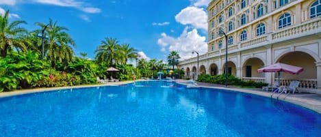 A large swimming pool with a building in the background.