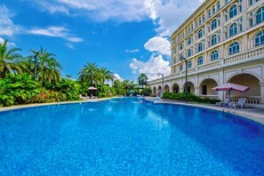 Uma piscina grande com um edifício ao fundo.