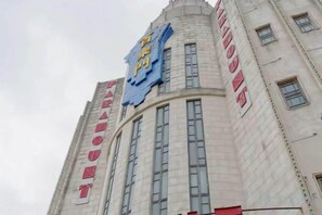 A building with a prominent sign reading 'HOTEL' and a smaller sign above it indicating 'HOTEL NAME'. - Xiqiao Mountain Qiaoyue Resort Hotel (Foshan)