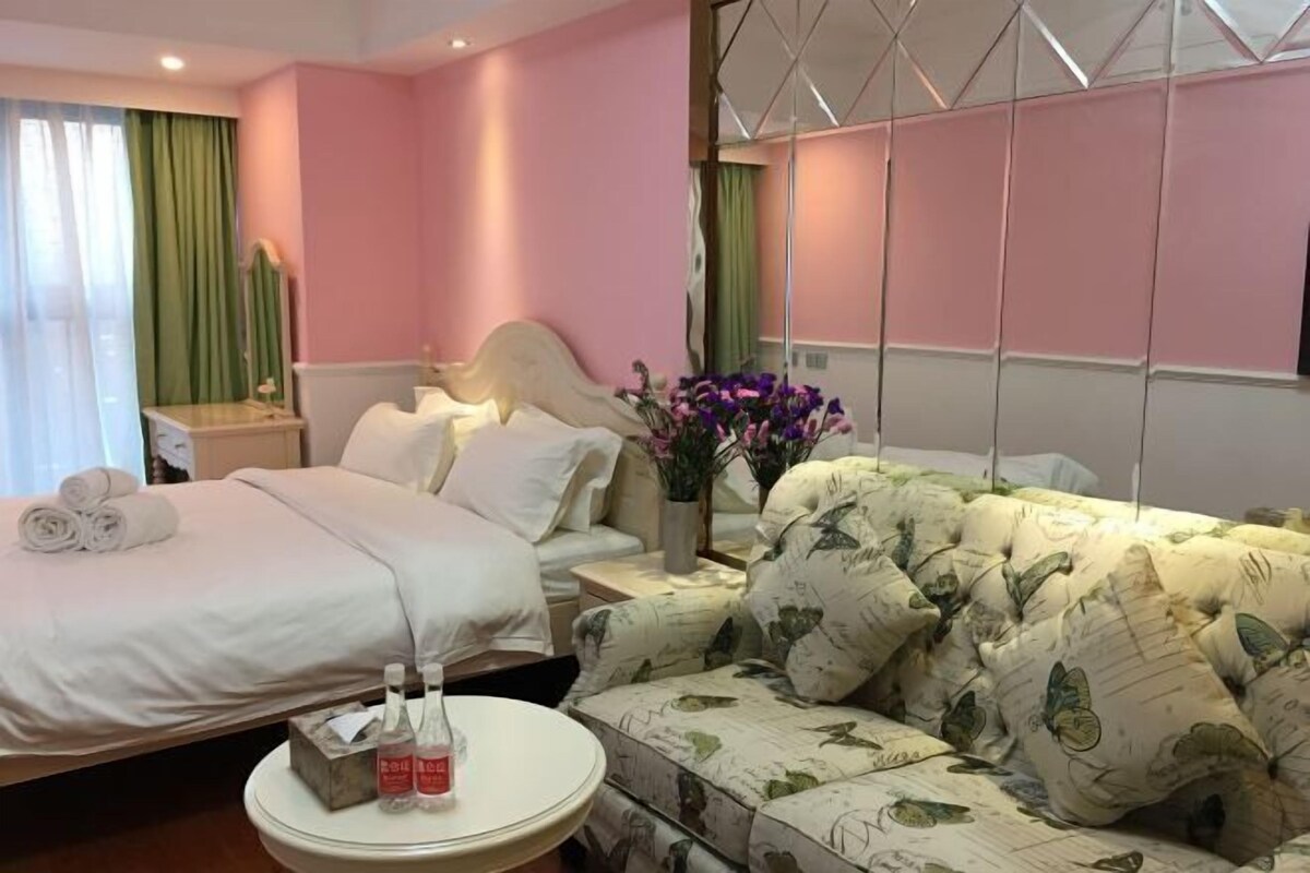 Ein Hotelzimmer mit einem Bett, einem Sofa, einem runden Tisch und einem Nachttisch.