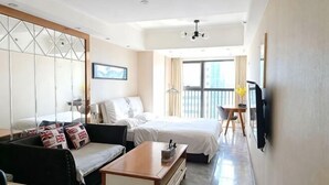 Une chambre d’hôtel équipée d’un lit, d’un canapé et d’un téléviseur fixé au mur.