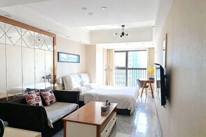 Ein Hotelzimmer mit Bett, Sofa und einem an der Wand befestigten Fernseher.