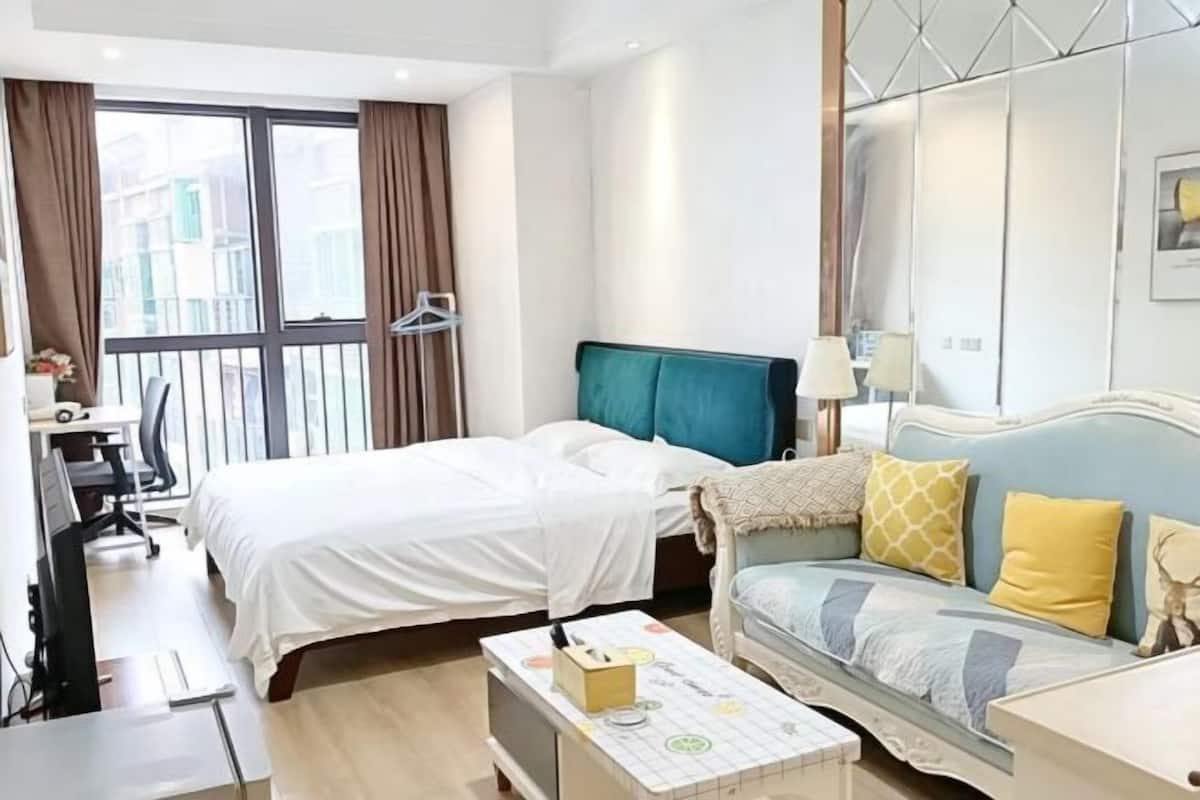 Een hotelkamer met een bed, een bank, een bureau en een stoel.