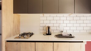 A kitchen with a gas stove, a kettle, and a sink. - Caline VIP Mews (Cape Town)