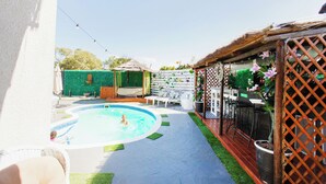 A backyard with a swimming pool, outdoor furniture, and a wooden deck. - Caline VIP Mews (Cape Town)