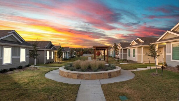 A residential area with houses, a central circular garden, and a sunset sky. - Charming house in Ferris (Ferris)