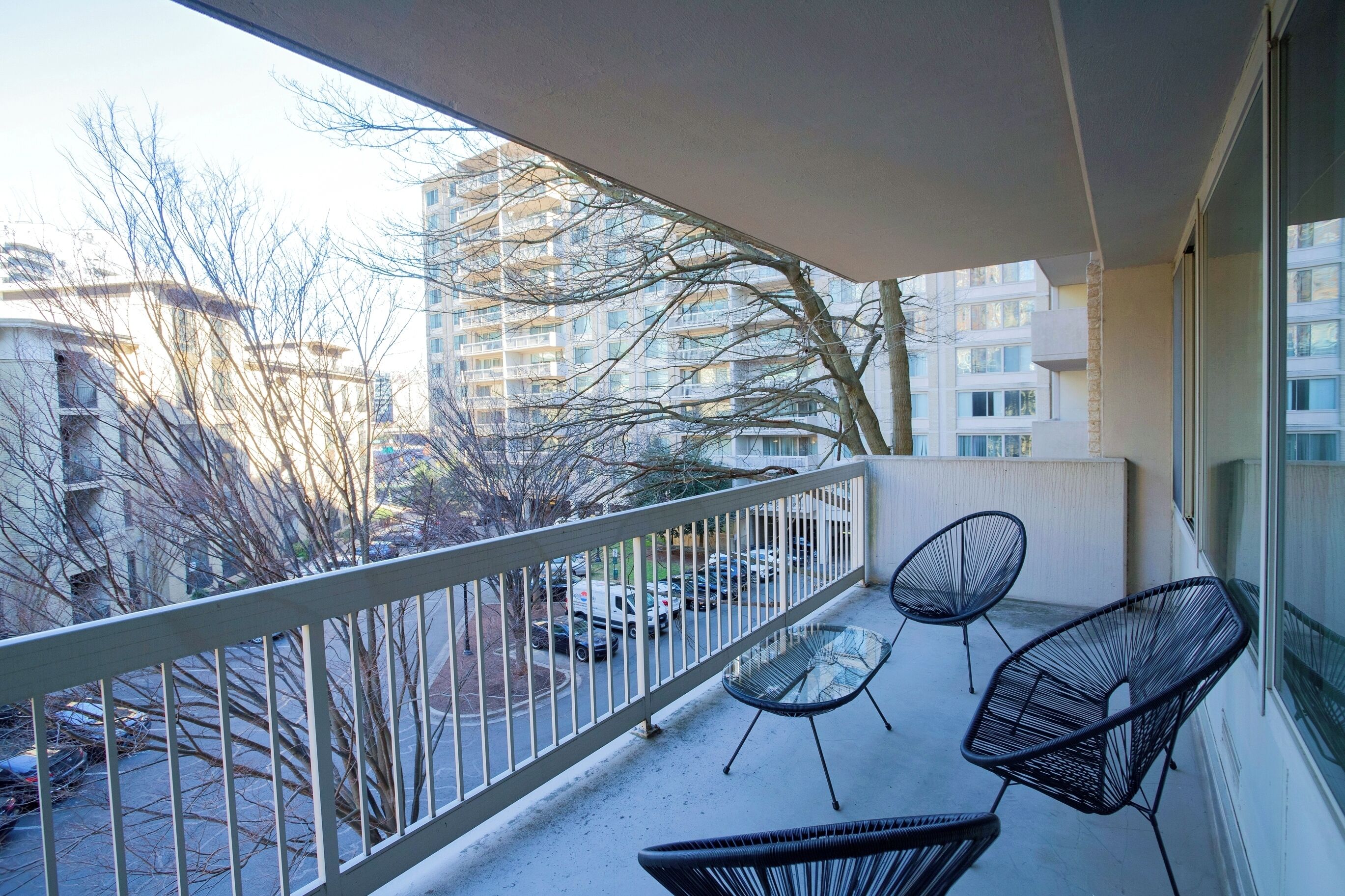 A balcony with a view of parked cars and buildings.