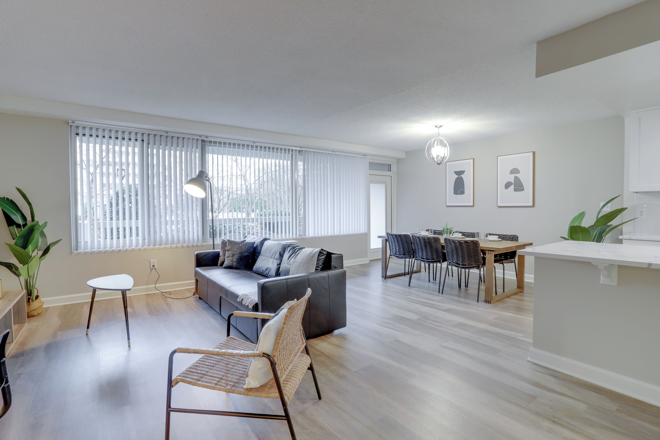 Un salon moderne comprenant un canapé, des fauteuils, une table à manger et un coin cuisine.
