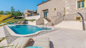 A stone building with a swimming pool, outdoor seating, and a staircase. - Stunning home in Brajkovici with sauna (Brajkovici)