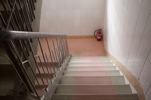 A staircase with metal railings and a fire extinguisher on the wall. - Nanning Tianli Hotel (Nanning)