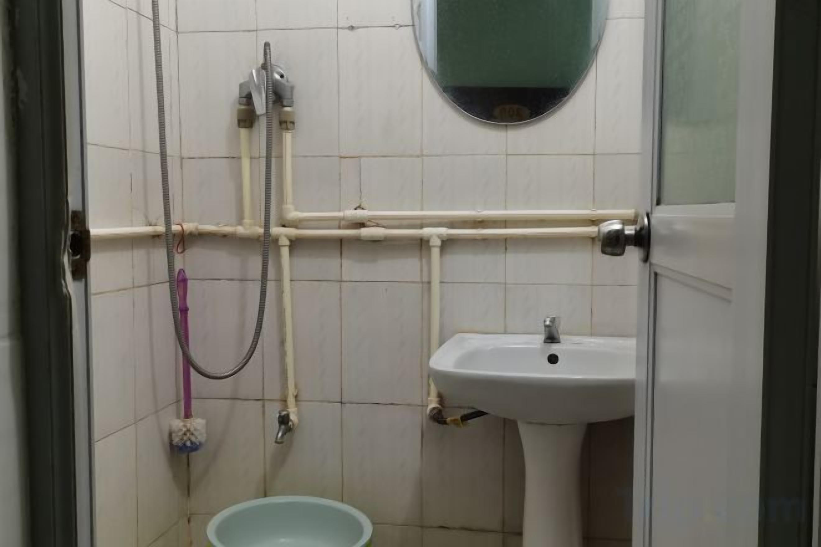 Un baño con lavamanos, espejo y zona de ducha.