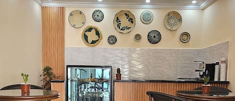 A restaurant with a modern interior, featuring a central counter, wooden paneling, and decorative plates on the wall.
