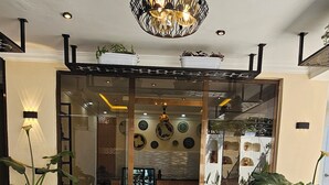 A room with a patterned floor, a dining area with chairs, a table, and a ceiling light fixture. - Calm Corner Addis  (Addis Ababa)