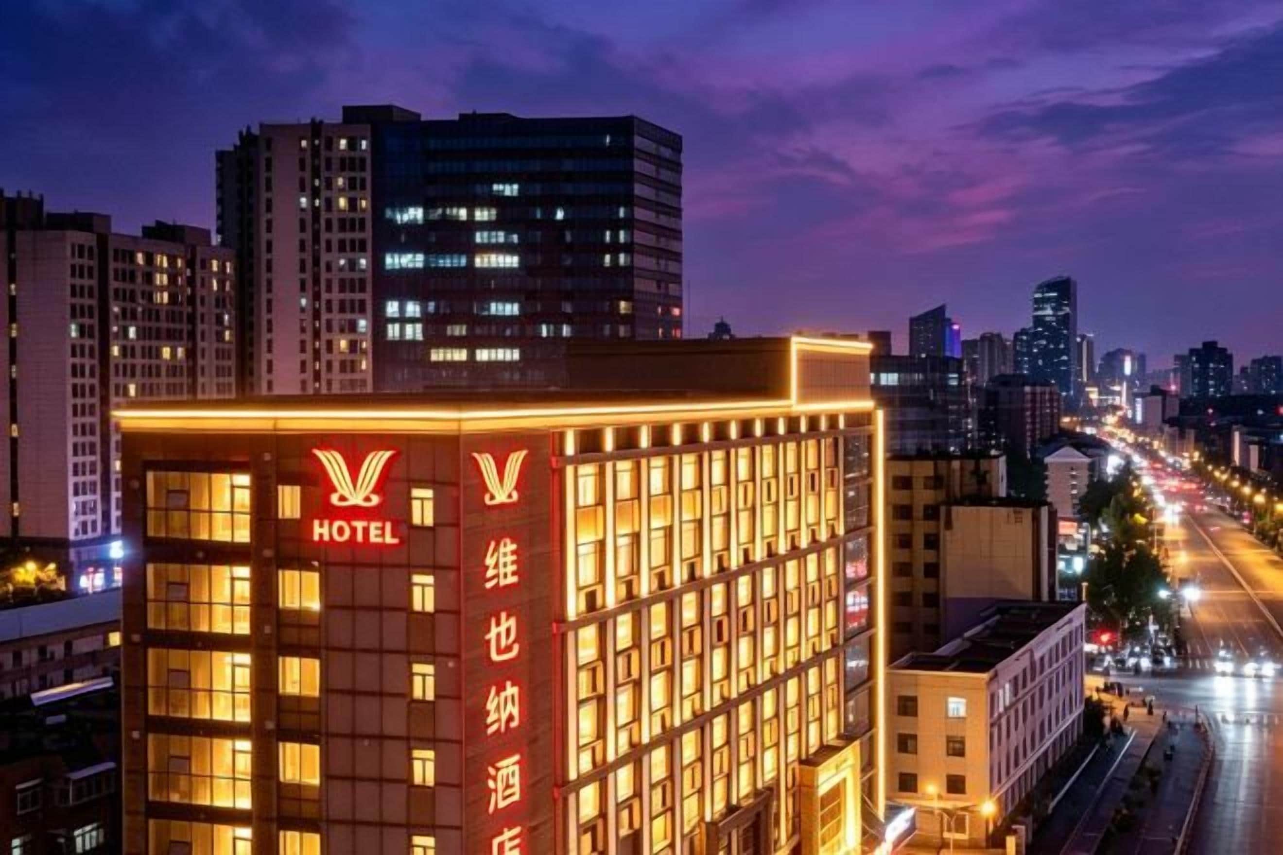 A hotel building with a prominent 'HOTEL' sign, multiple floors, and a cityscape in the background.
