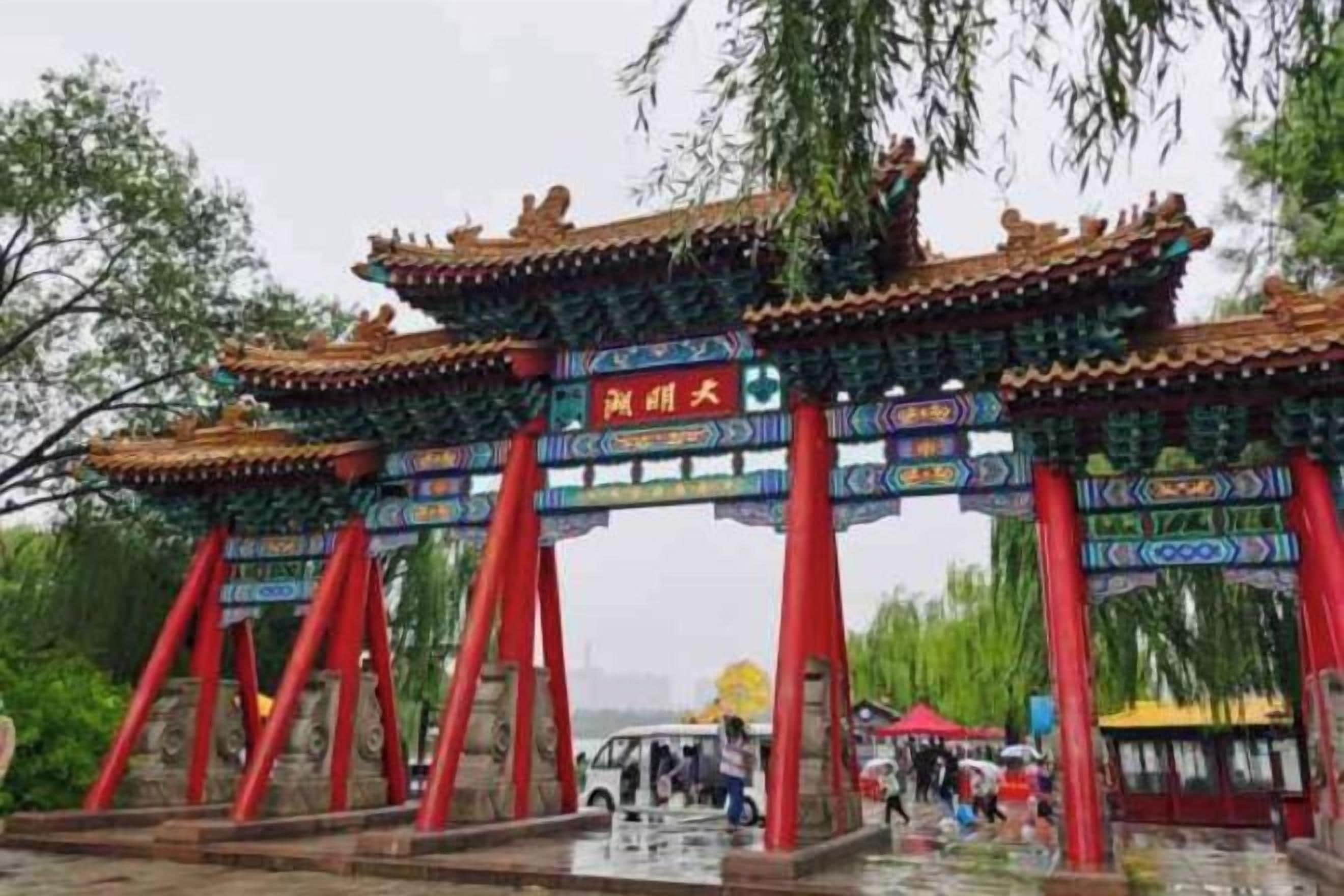 Um portão tradicional chinês com pilares vermelhos e elaborados detalhes no telhado.