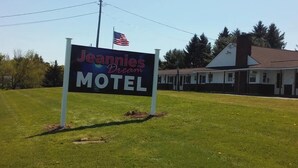 Señal de Motel Jeannies Dream con una bandera al fondo.