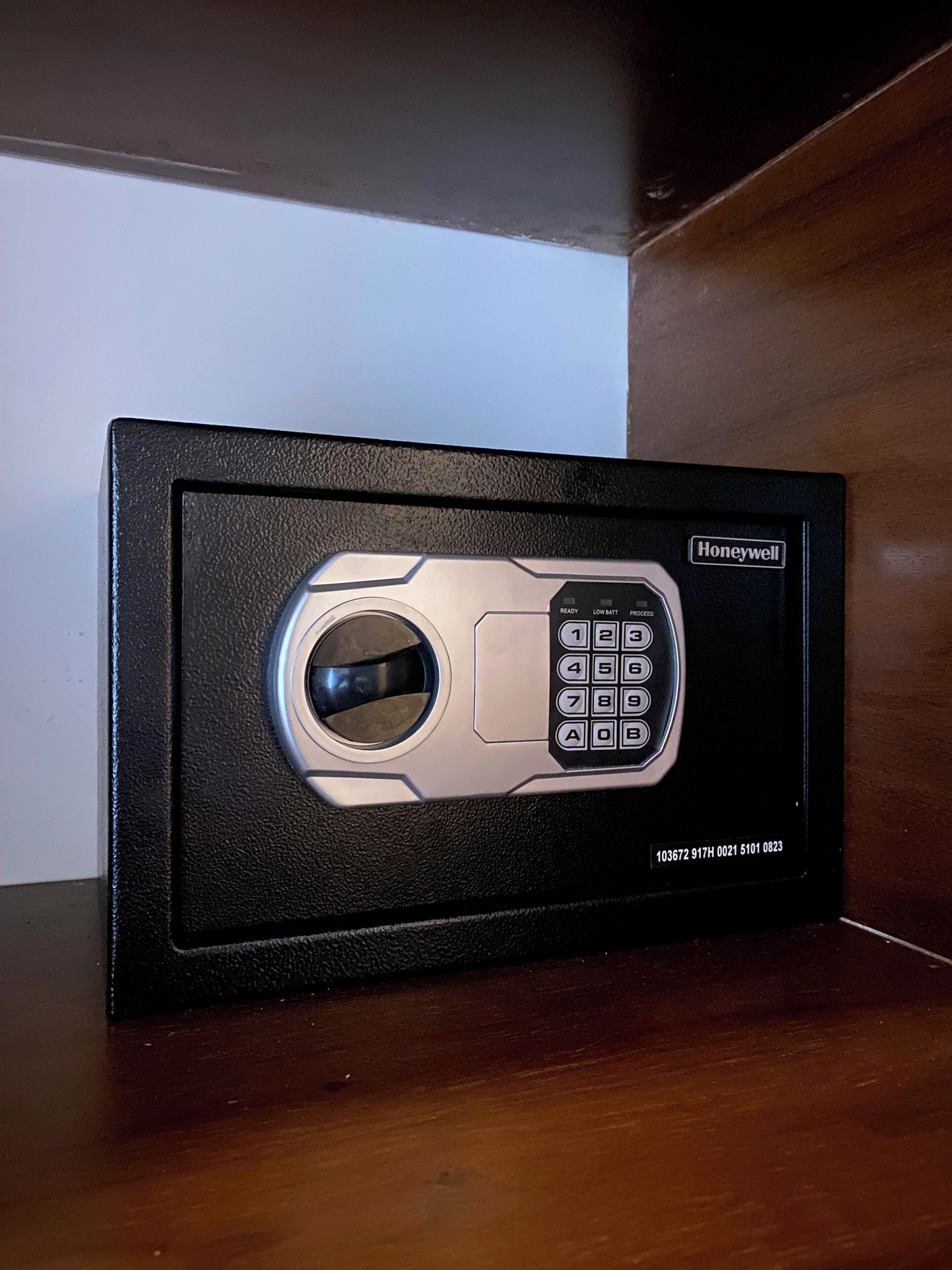 Una caja fuerte Honeywell con teclado y cerradura, sobre una superficie de madera.