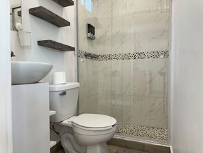 Une salle de bain moderne équipée de toilettes, d’un lavabo et d’une douche.
