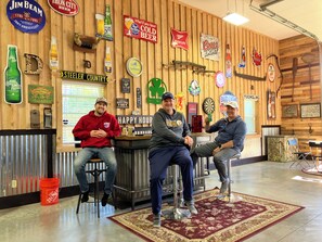A bar with wooden walls, various beer signs, and stools. - Bull Run Lodge Unique 2000 sq. Barndominium Edinboro / Albion / Elk Creek Twp. (Albion)