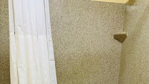 Un baño con bañera, cortina de ducha y una toalla colgada en la bañera.