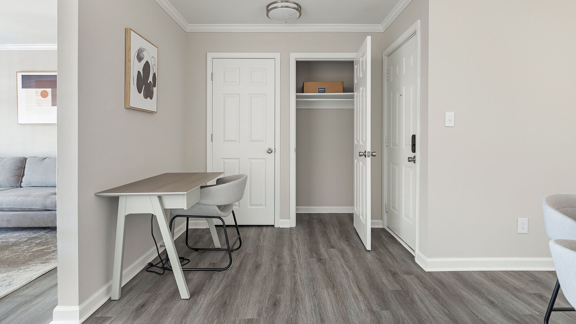 A compact living space with a desk, chair, and a closet.