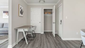 A compact living space with a desk, chair, and a closet.
