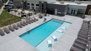 Ein Pool auf dem Dach mit Liegestühlen und einer überdachten Sitzgelegenheit.