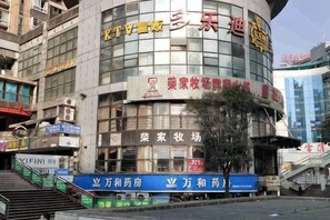 A multi-story building with signage for a hotel and various businesses. - 116 Business Hostel (Chongqing)